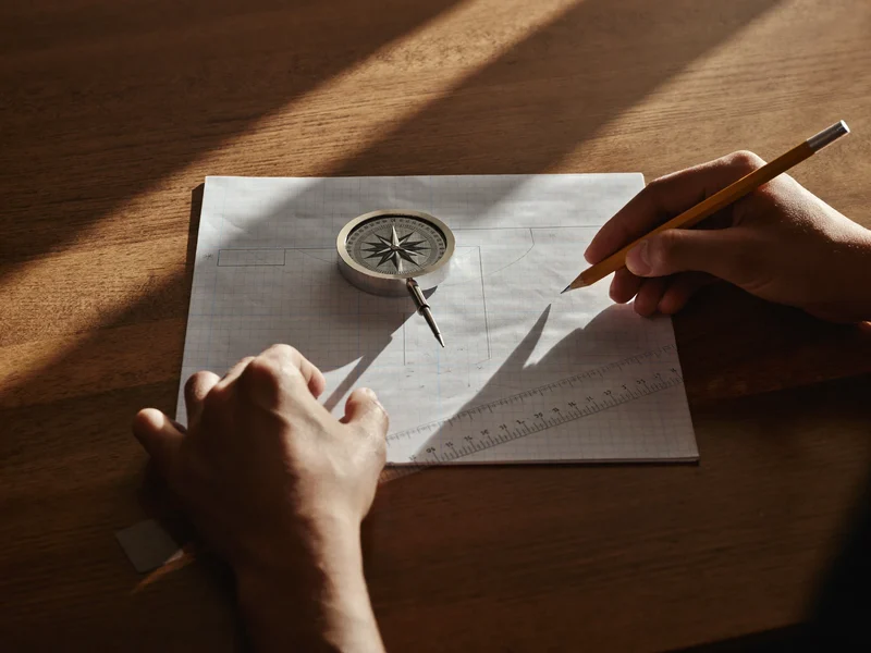 Illustration af hænder, der løser en geometriopgave med blyant, lineal og passer